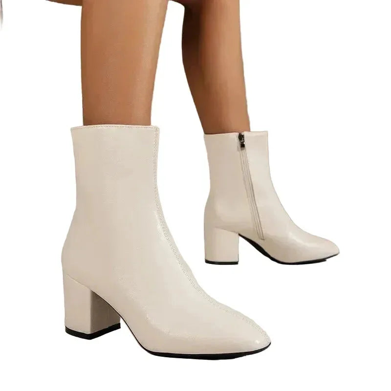 Front view of two beige ankle boots showing zip closure and rounded block heel