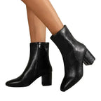 Angled front view of black ankle boot showing pointed toe and stitched seam detail
