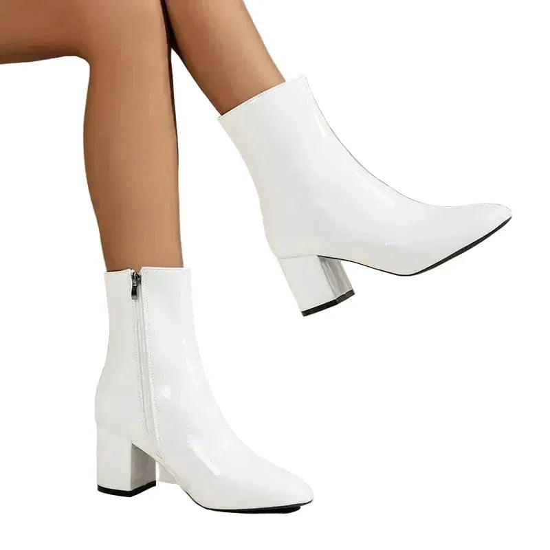 Close angled view of black ankle boot on white background showing sheen of the upper