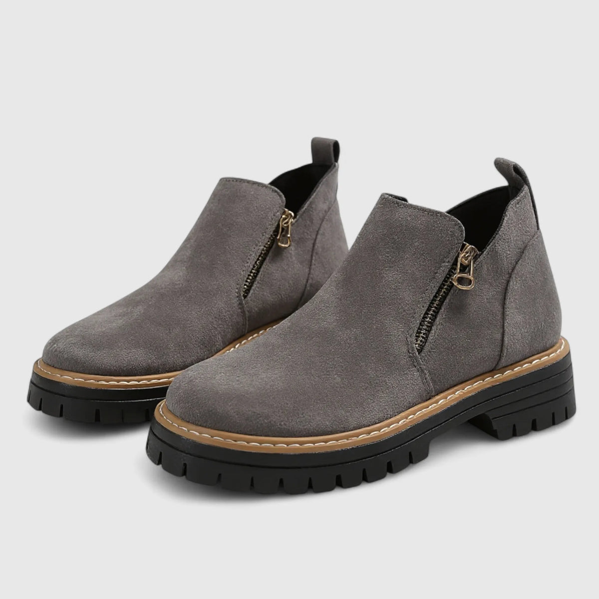Grey suede ankle boots with contrast tan welt stitching and chunky black lugged sole