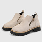 Beige suede ankle boots with side zip closure and rounded toe, shown from a front angle