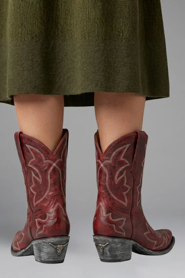 Back view of red embroidered ankle boots showing stacked heel with longhorn emblem