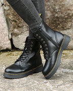 Close-up of black lace-up boot showing eyelets, zip detail and contrast yellow stitching on the sole