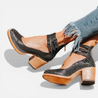 Black snake-embossed leather platform heels with cutout ankle straps, styled with frayed denim jeans
