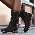 Black leather lace-up boots shown from behind with dark laces criss-crossing up to the studded ankle cuff