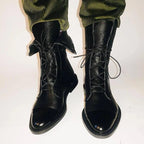 Black leather lace-up boots paired with a lace dress hem and a black leather bag with gold ring handle
