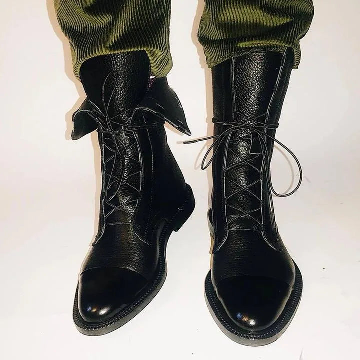 Black leather lace-up boots paired with a lace dress hem and a black leather bag with gold ring handle