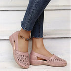 Side view of light pink perforated leather flat with elasticated ankle strap and wedge sole