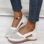 White laser-cut leather flat shown from above, highlighting the perforated toe pattern and stitched trim