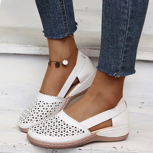 White laser-cut leather flat shown from above, highlighting the perforated toe pattern and stitched trim