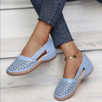 Blue perforated leather flat showing the cushioned wedge sole and scalloped edge detail