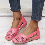 Pink laser-cut leather flat highlighting the triangular perforation pattern and slip-on fit