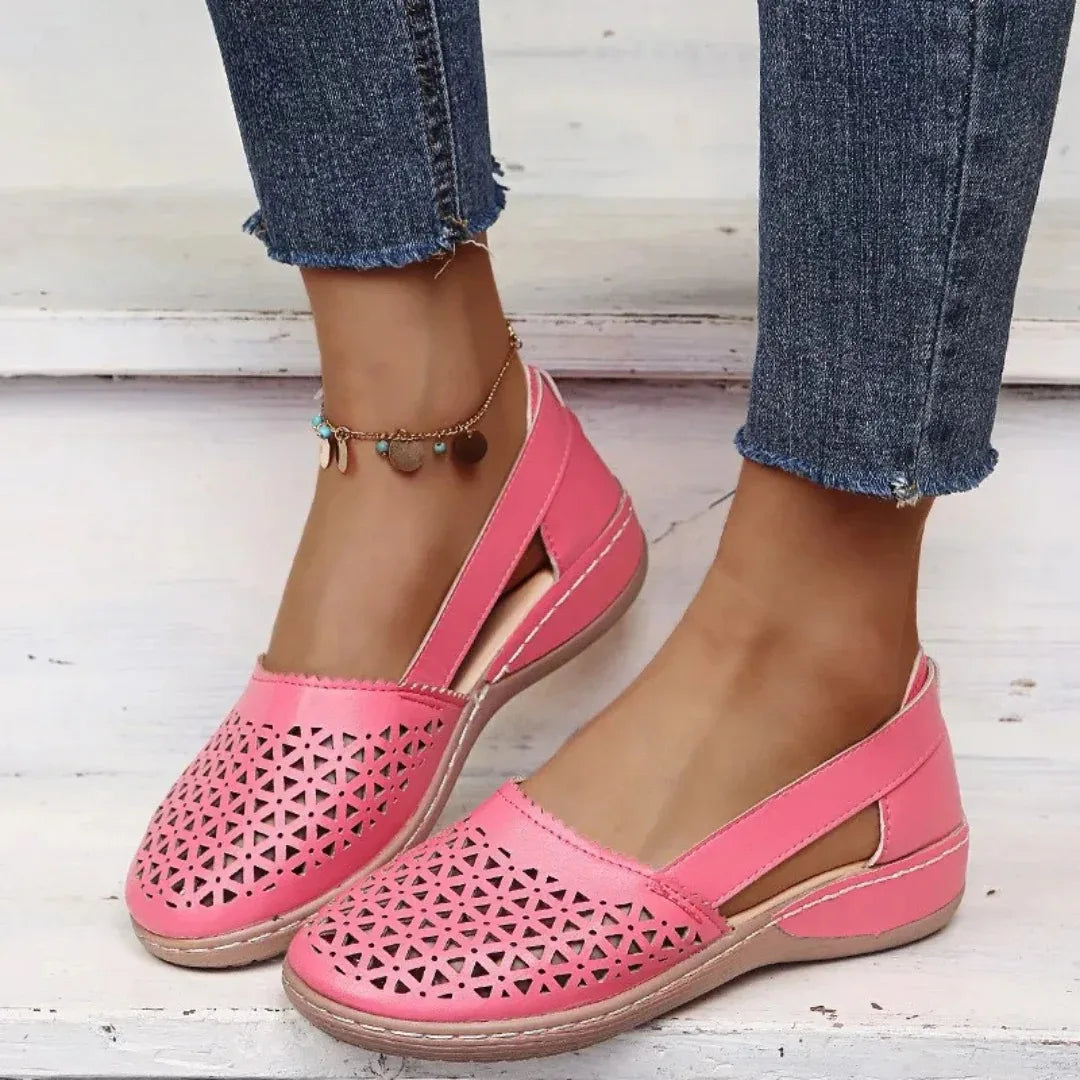 Pink laser-cut leather flat highlighting the triangular perforation pattern and slip-on fit