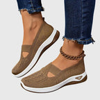 Pair of brown knitted slip-on trainers with white ridged soles and gold ankle chain accessory