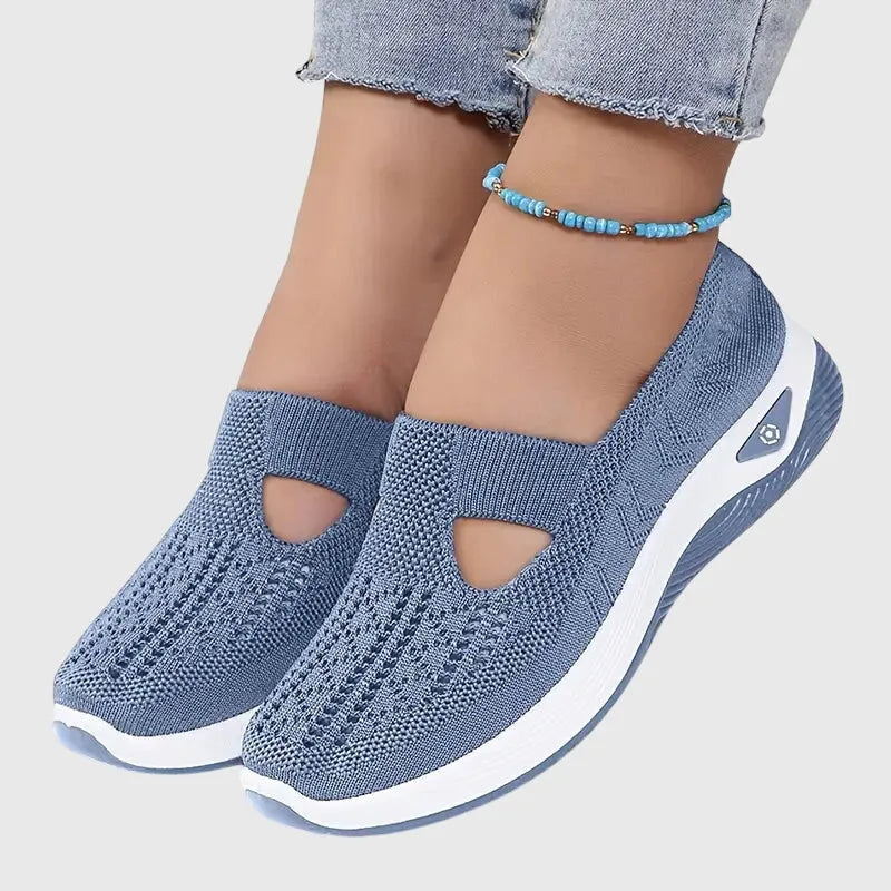 Blue knitted slip-on trainers with cut-out detail and thick white sole, worn with cropped jeans