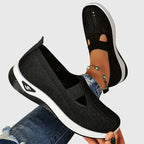 Close-up of black slip-on trainer sole showing tread pattern and side logo detail