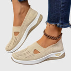 Angled view of black knitted trainers stacked showing perforated texture and ribbed collar