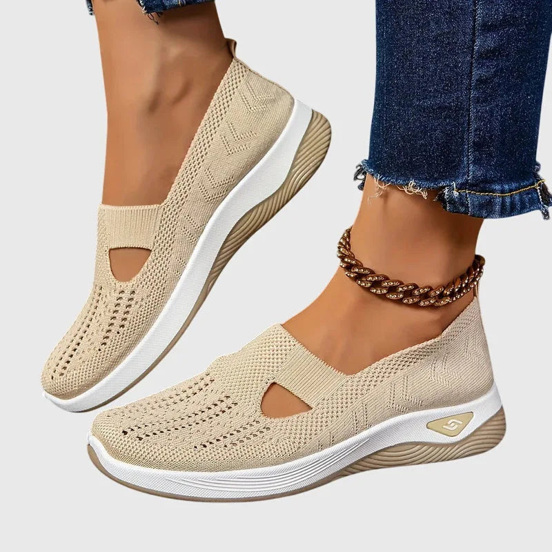 Angled view of black knitted trainers stacked showing perforated texture and ribbed collar