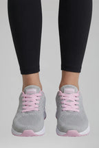 Front view of grey and pink knit trainers with pink laces worn with black leggings