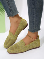 Mustard yellow knitted flats worn with cropped jeans, showing low-cut vamp and slim sole