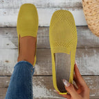 Mustard yellow flats shown from above and sole view, highlighting knit texture and flat outsole