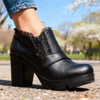 White leather ankle boot with sheer lace trim at the ankle and polished side zip, worn with rolled jeans
