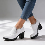 Front angled view of black ankle boots highlighting round toe, platform sole and ridged tread