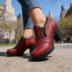 Burgundy ankle boots on crossed legs showing stitched seam detail and rich leather finish