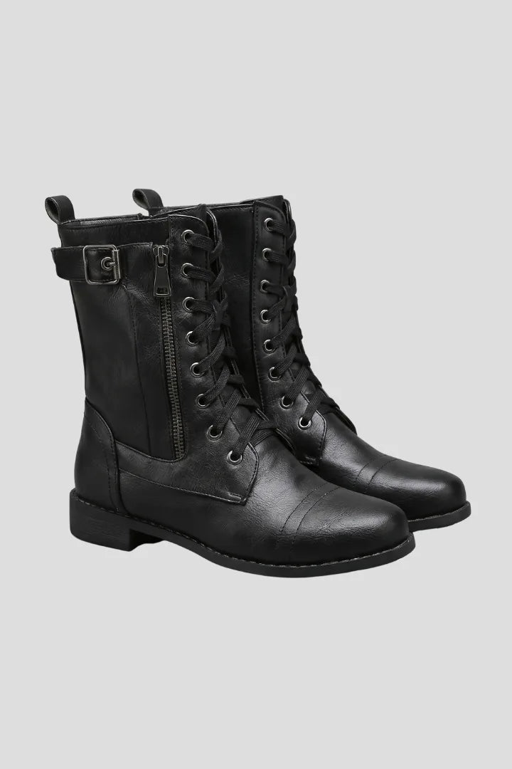 Front three-quarter view of black lace-up combat boots with side zip and buckle strap at the ankle