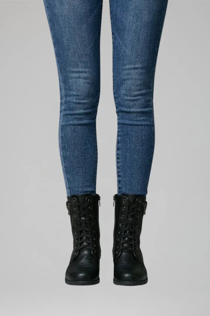 Close-up front view of black lace-up ankle boots with zip fastening and eyelet lacing on jeans