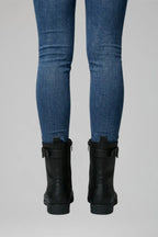 Close-up back view of black combat boots highlighting the heel pull tab and ankle buckle