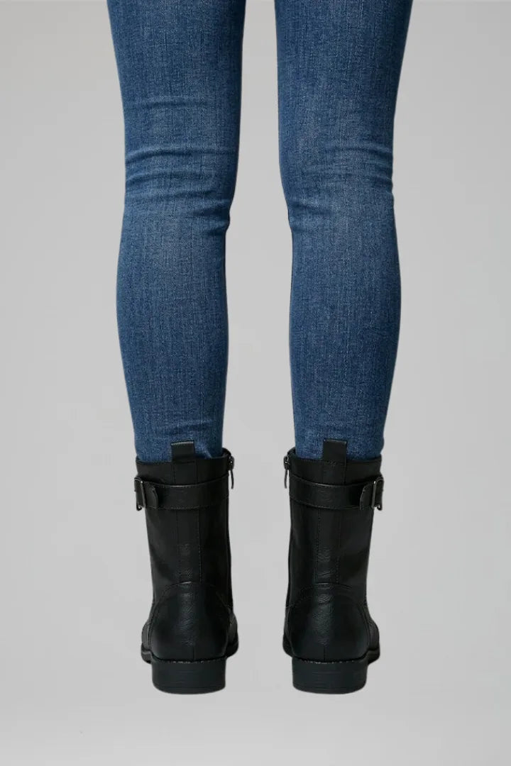 Close-up back view of black combat boots highlighting the heel pull tab and ankle buckle