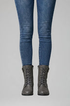 Front view of grey lace-up combat boots with side zip, worn with blue skinny jeans