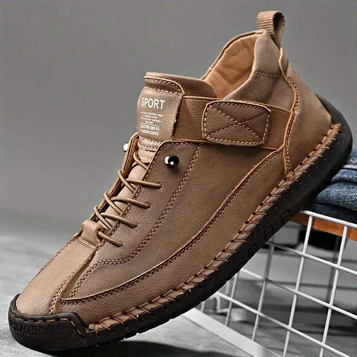 Close-up of red trainer pair crossed together displaying hand-stitched leather panels
