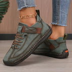 Olive green leather trainer with brown laces and stitched trim, styled with cropped denim