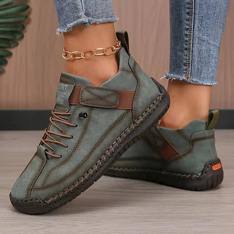 Olive green leather trainer with brown laces and stitched trim, styled with cropped denim