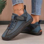 Blue-grey leather trainer paired together showing stitched sole and side strap detail
