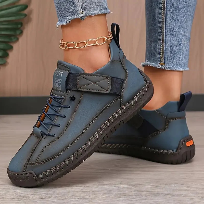 Blue-grey leather trainer paired together showing stitched sole and side strap detail