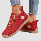 Red leather trainer with contrasting tan laces and strap, close-up side view