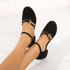 Top-down view of black dance shoes showing rounded toe, crossover patent straps and ankle buckle detail