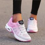 Side view of pink and grey ombre mesh trainer with white laces and pink outsole, worn while walking