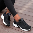 Angled view of black mesh trainers with white air-cushion sole and Fashion branded heel tab