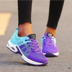 Rear view of aqua and purple ombre mesh trainers with white soles, worn on foot outdoors