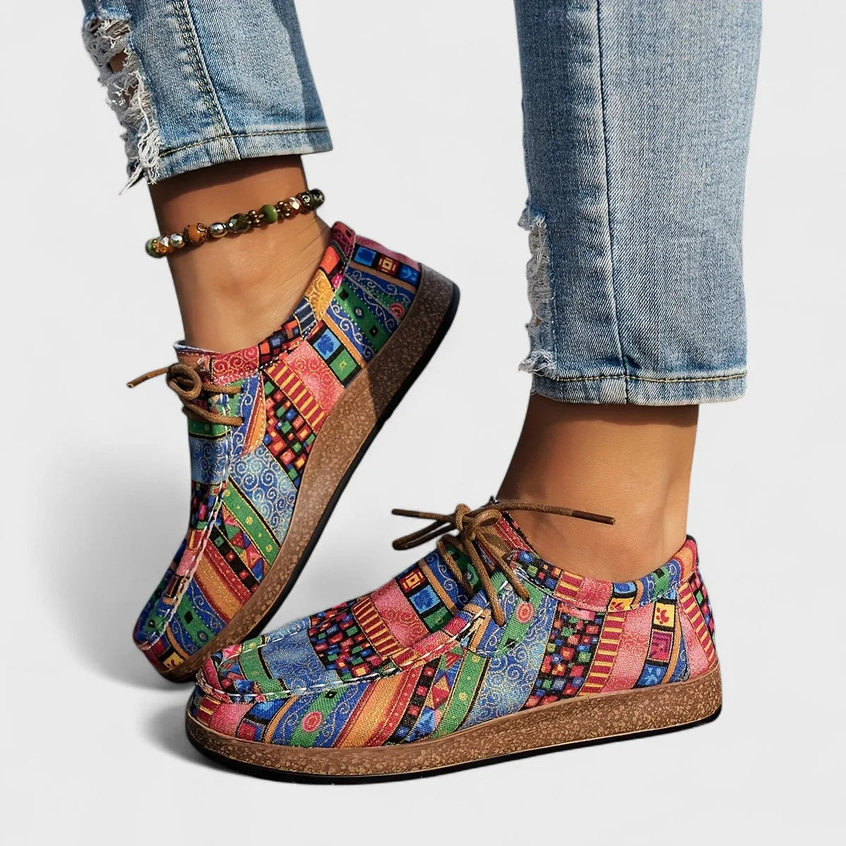Side profile of pink, blue and green patchwork comfort shoes showing the moccasin-style stitched toe.