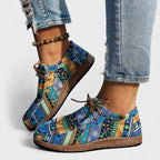 Side view of blue and gold patchwork lace-up shoes highlighting the textured sole and tan laces.