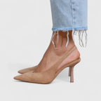 Side view of beige suede pointed toe slingback heel worn with light blue frayed-hem jeans