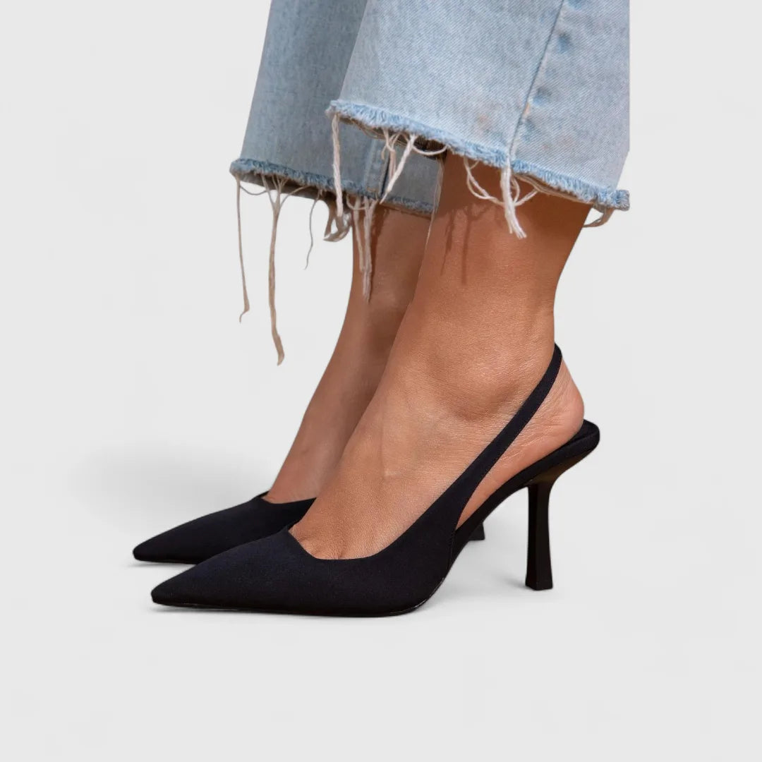 Black suede slingback pumps with pointed toe and slim heel, paired with dark washed jeans