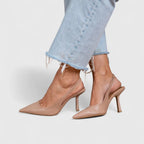 Beige leather slingback heels shown from the side, highlighting the pointed toe and slender heel