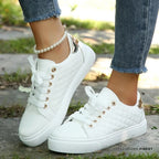 White quilted lace-up trainers with gold eyelets and metallic heel tab, worn with cropped jeans and a pearl anklet.