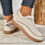 Beige suede ankle boot with fur trim and bow detail on the heel, paired with cropped denim